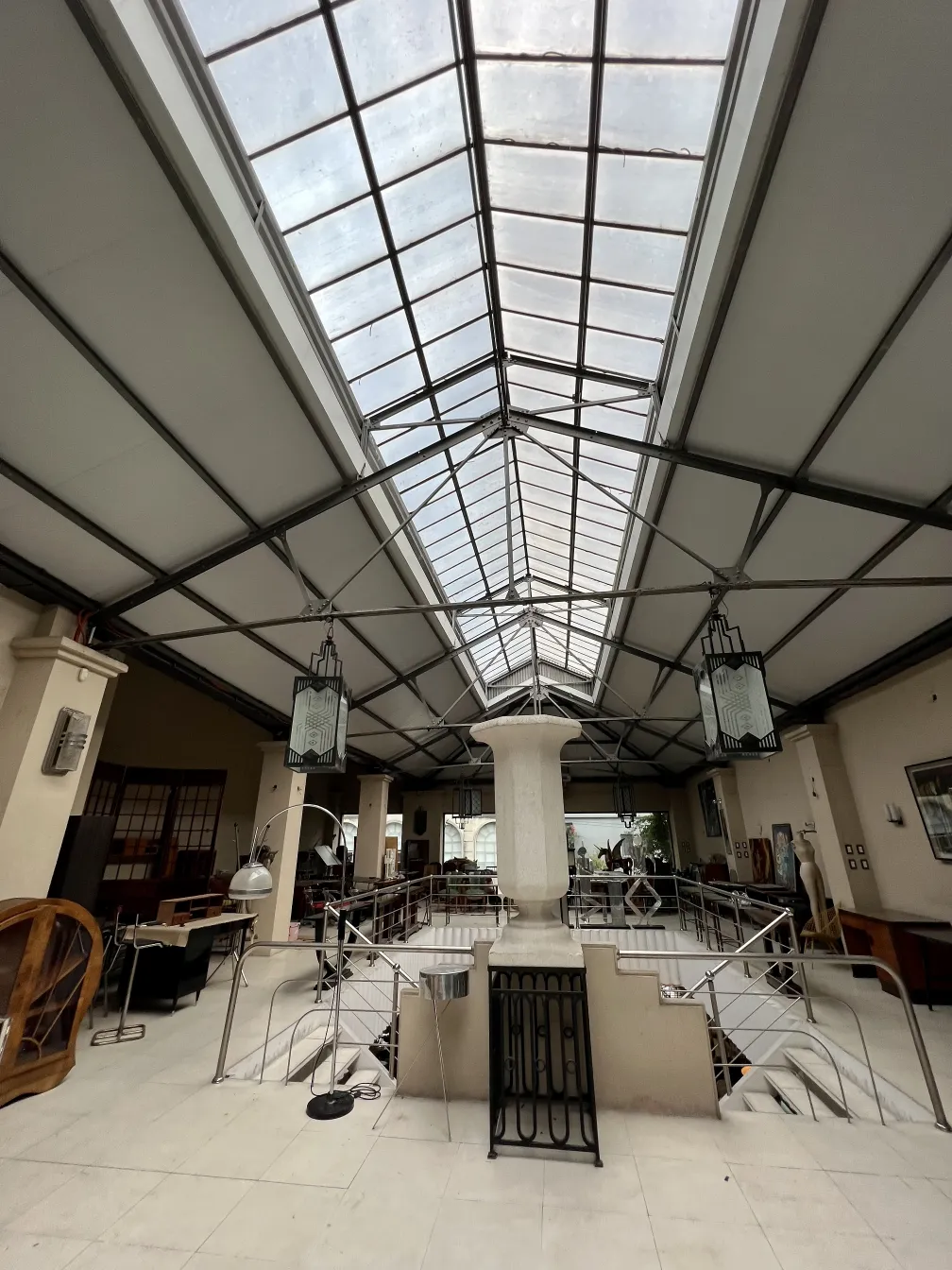 Duas farolas antigas penduradas em um interior espaçoso com arquitetura moderna