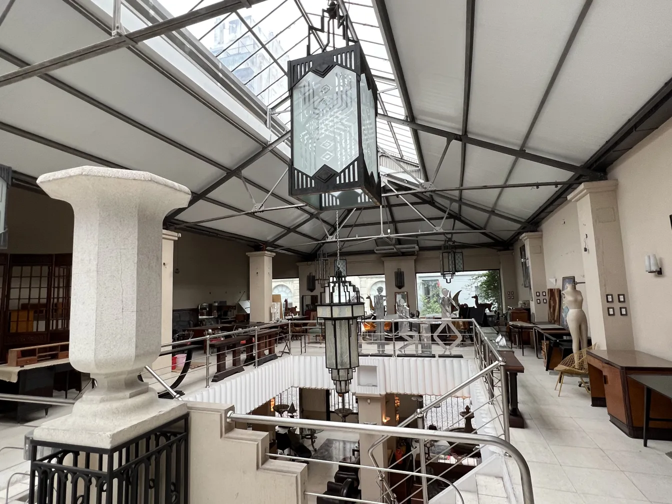 Two antique decorative lanterns hanging in a spacious area with a railing and a vintage atmosphere.