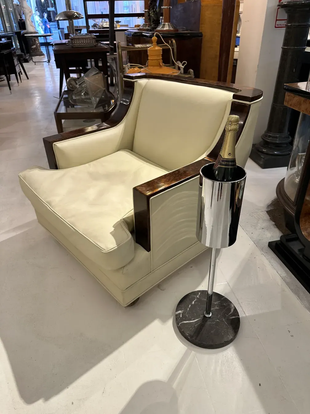 Champanera antigua con botella de champán sobre sofá moderno