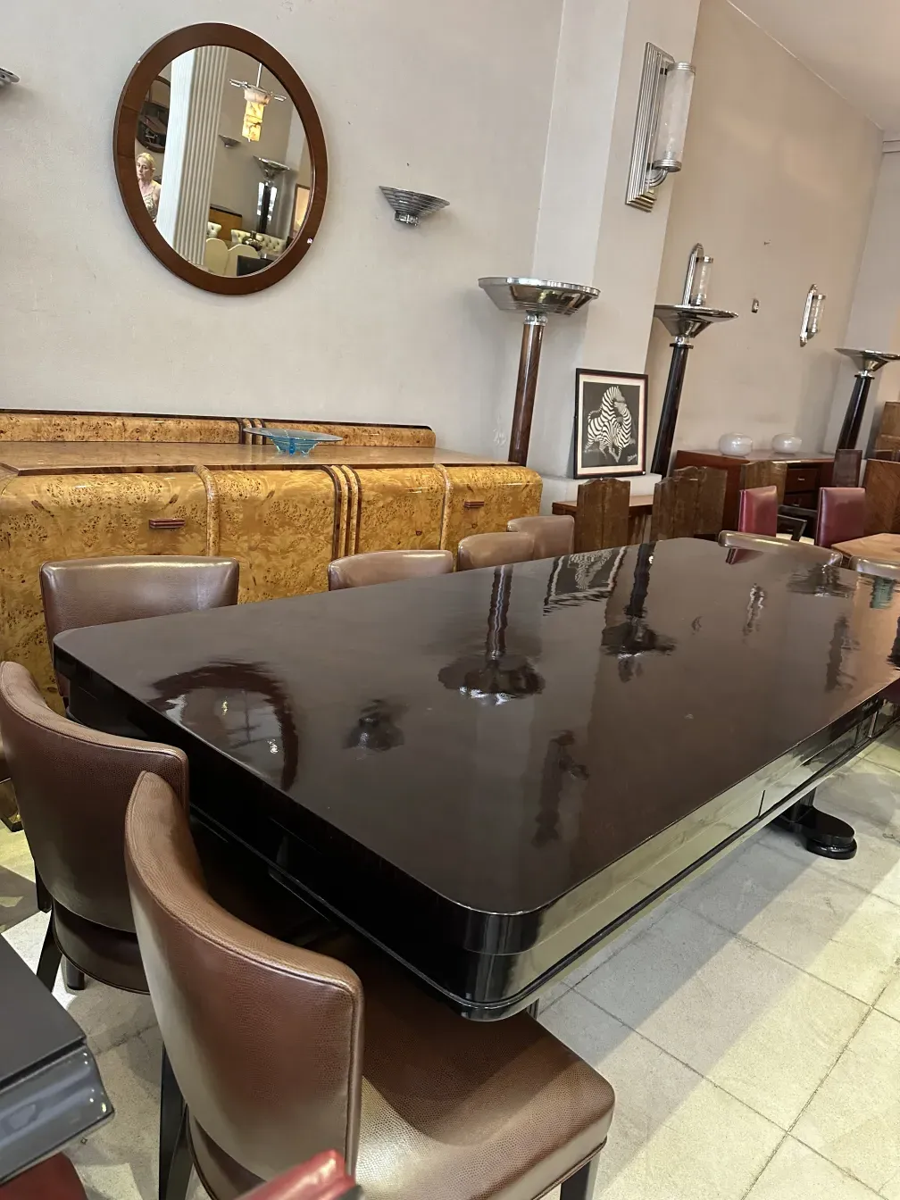 aparador antiguo de madera con espejo redondo y sillas de cuero