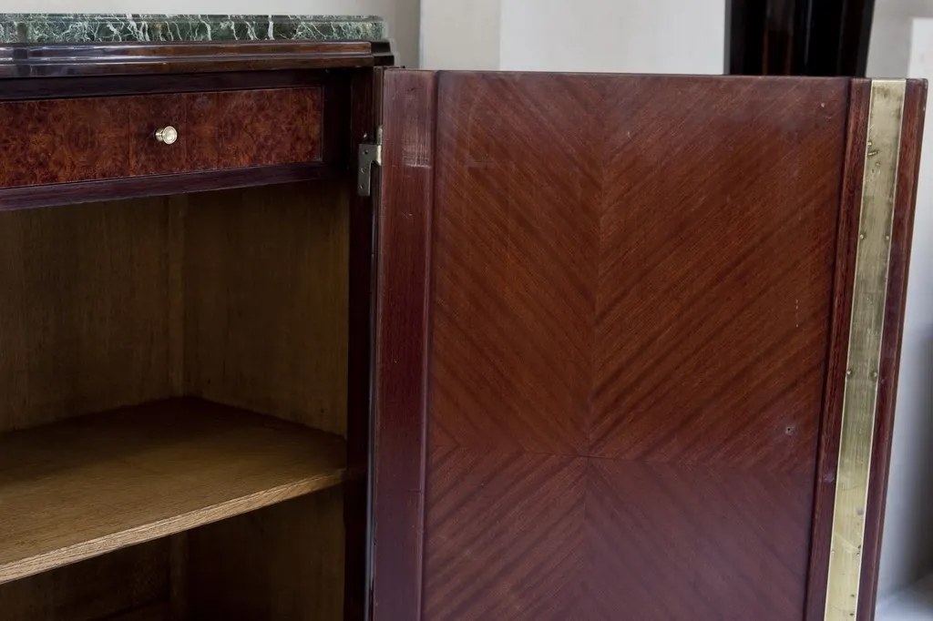Antique sideboard with an elegant design, open doors and visible interior shelves.