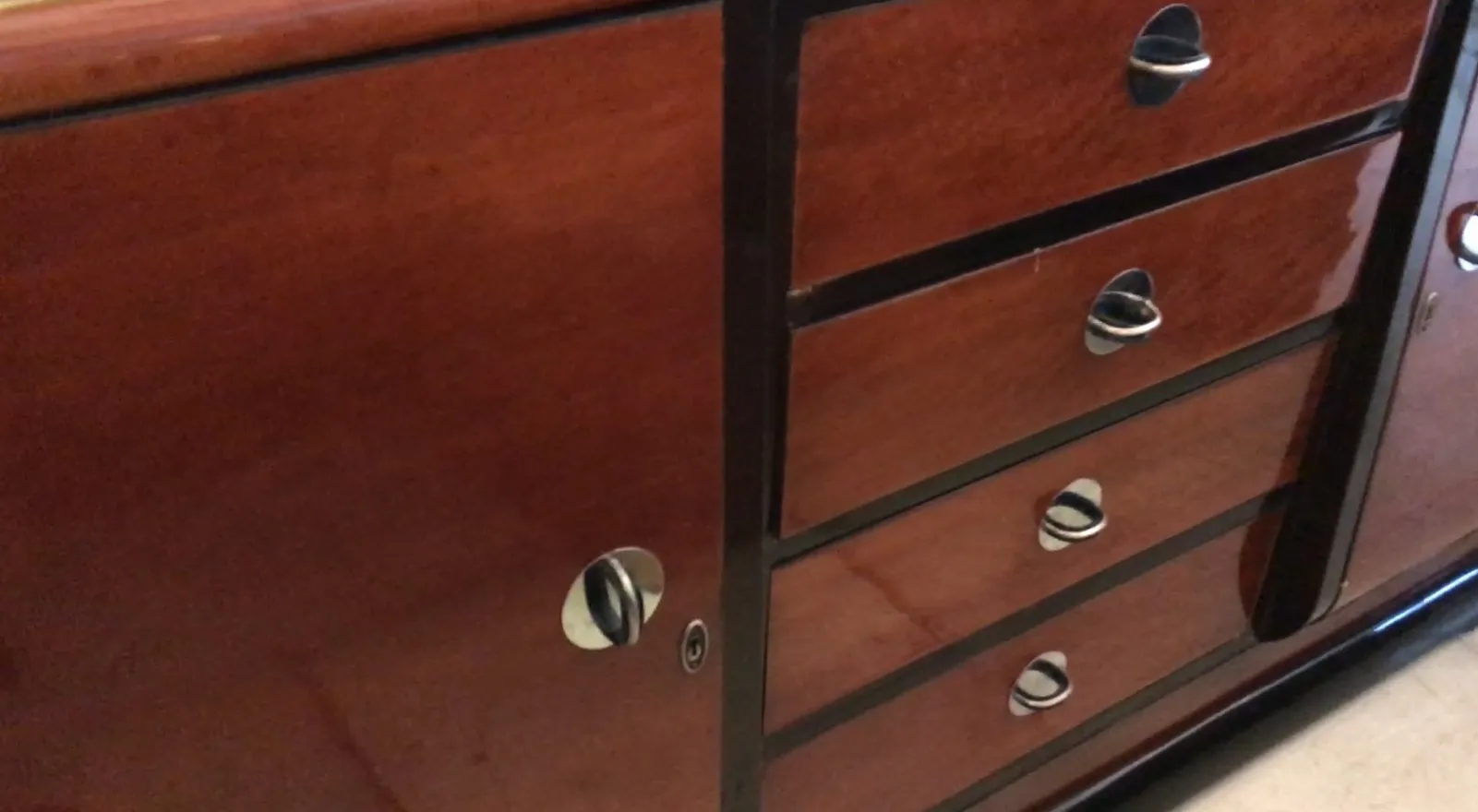 aparador antigo de madeira com puxadores de metal em um ambiente aconchegante