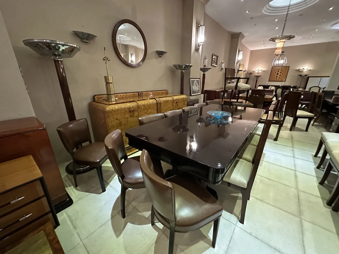 Aparador antiguo en un entorno de comedor elegante, con sillas y mesa.