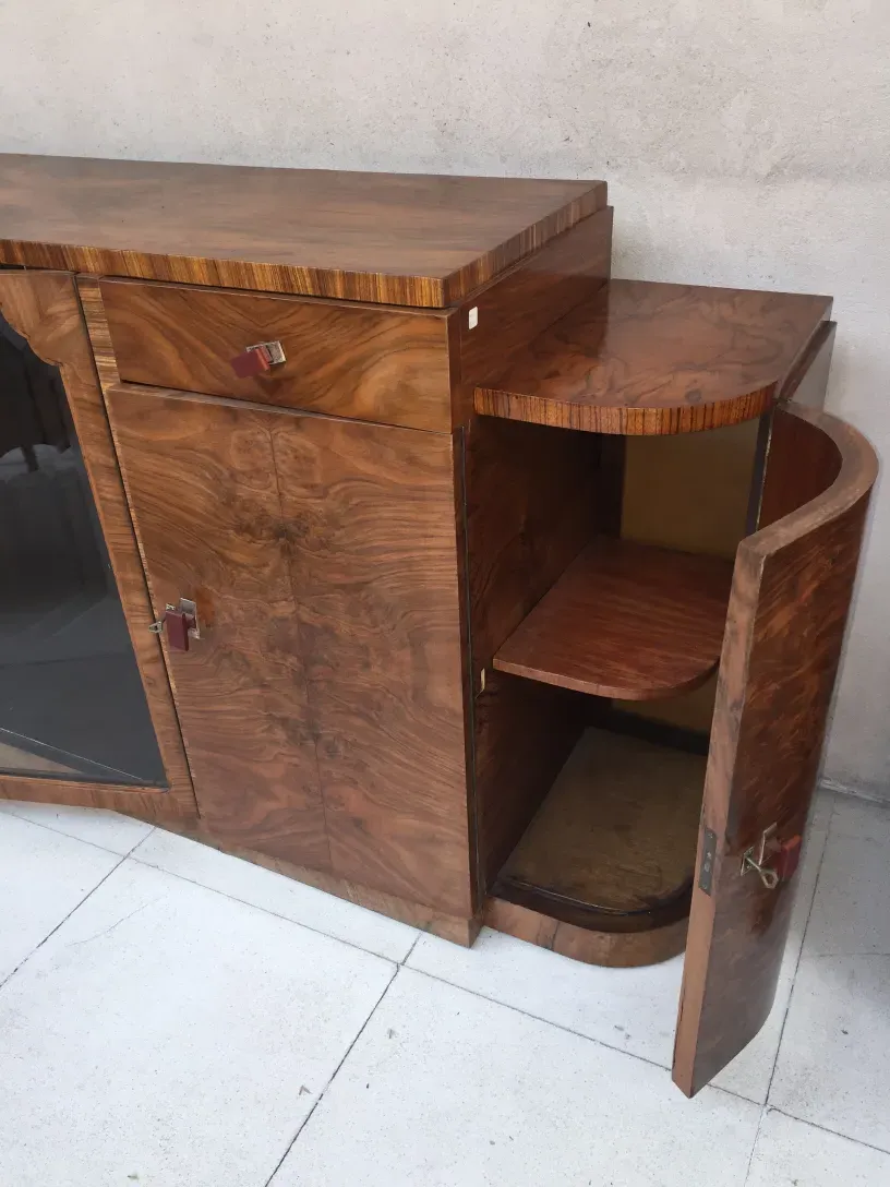 Aparador antiguo de madera con estantes curvados y puertas.