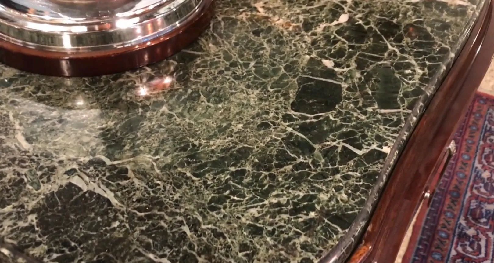 Credenza antica decorativa con un design in cima e dettagli visibili.