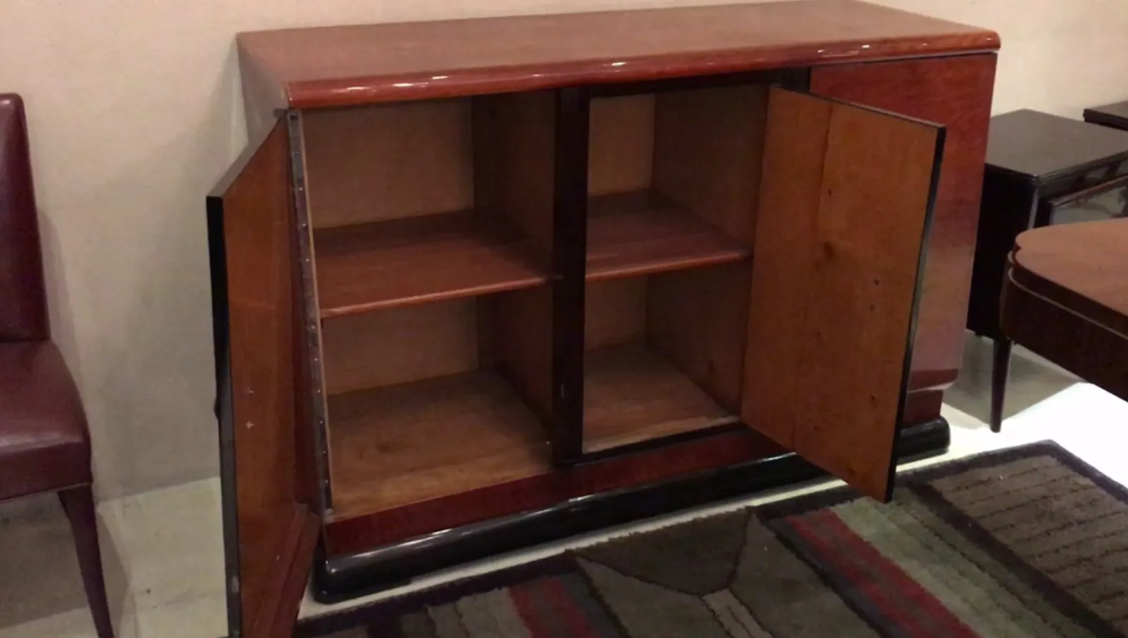 Credenza antica aperta con spazio di stoccaggio visibile, circondata da un'atmosfera accogliente.