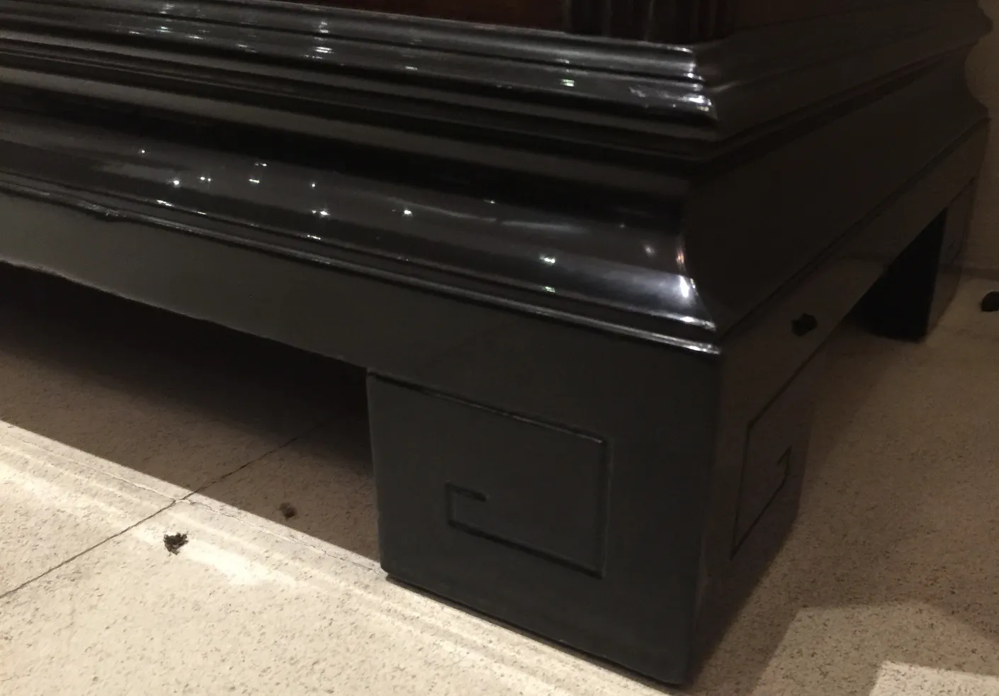 Credenza antica nera con design elegante e dettagli unici sui bordi, in un ambiente classico.