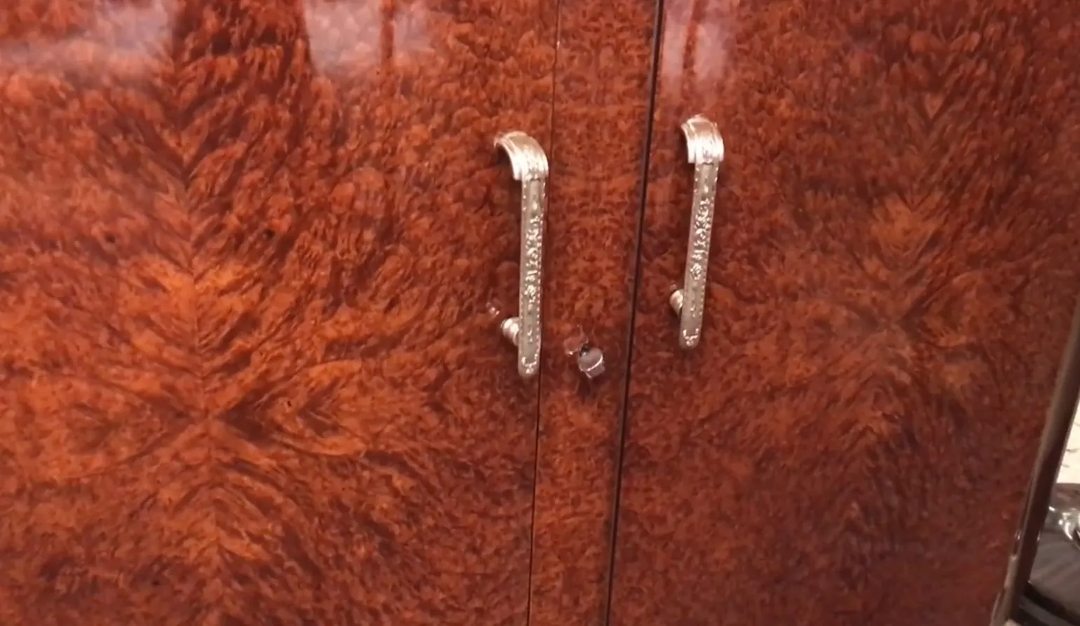 aparador antiguo de madera con puertas decoradas y un cierre