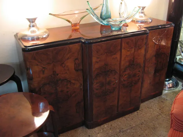 credenza antica in legno con decorazioni dettagliate, circondata da elementi decorativi chiari