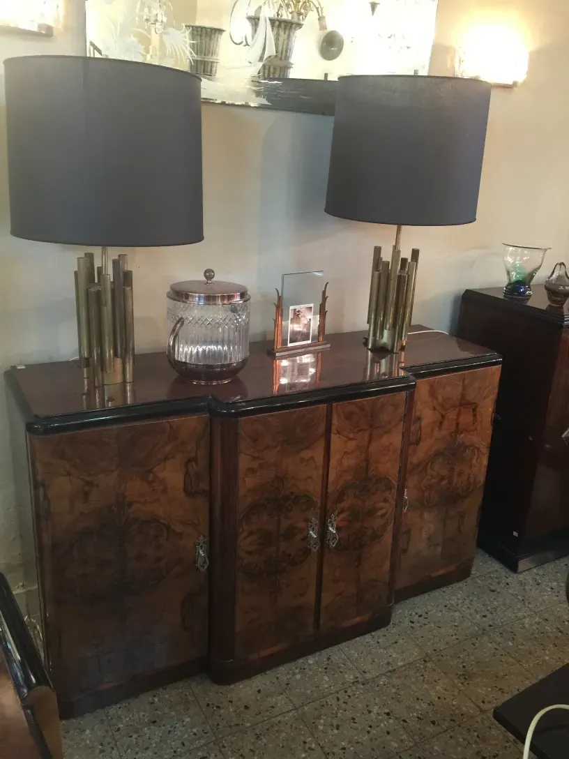 Credenza antica con design ornamentale, con lampade e oggetti decorativi