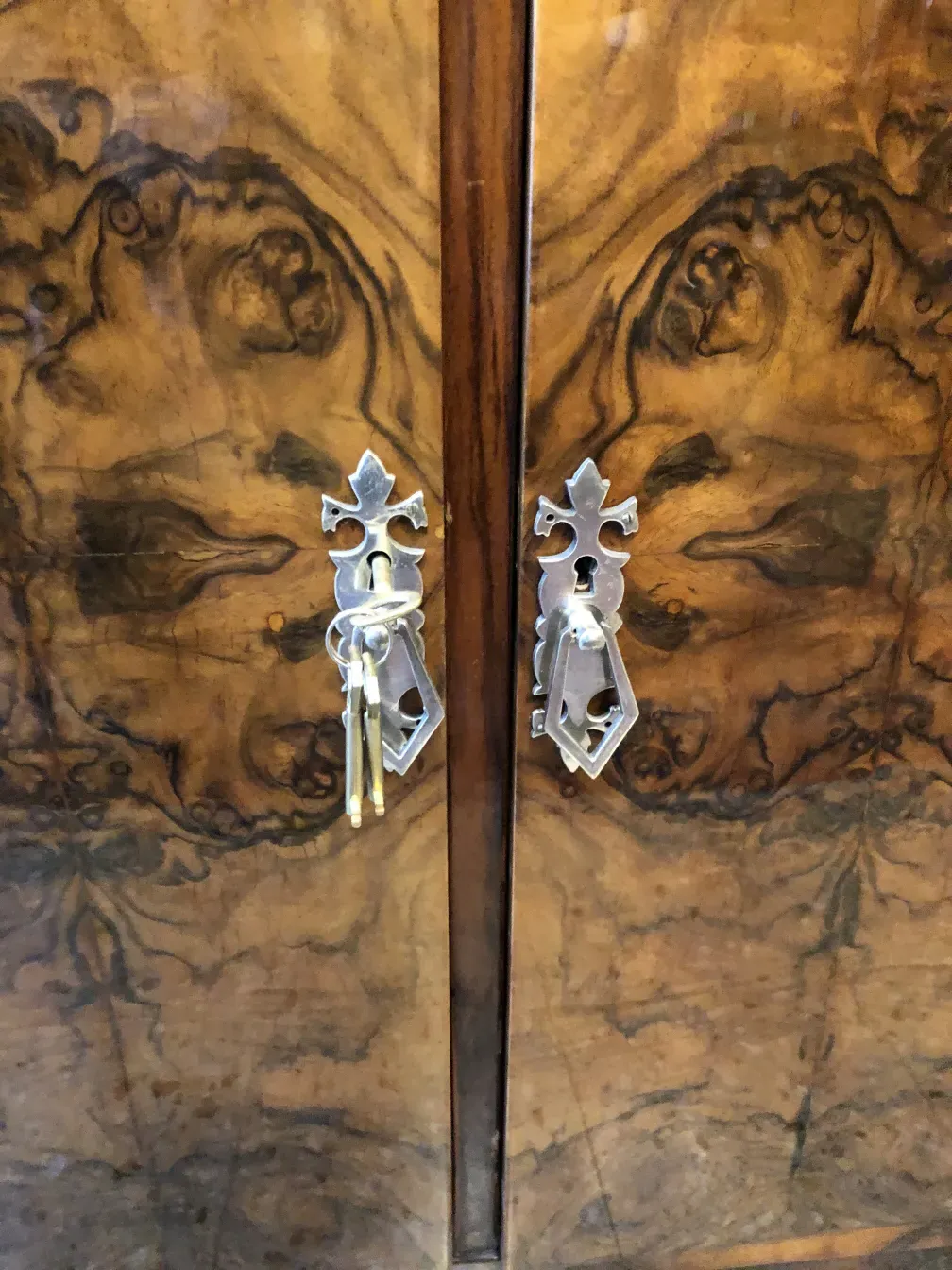 Credenza antica con finitura lucida e chiavi decorative.