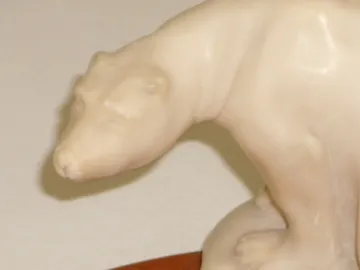 Cenicero de pie antiguo con forma de oso, en un entorno simple.