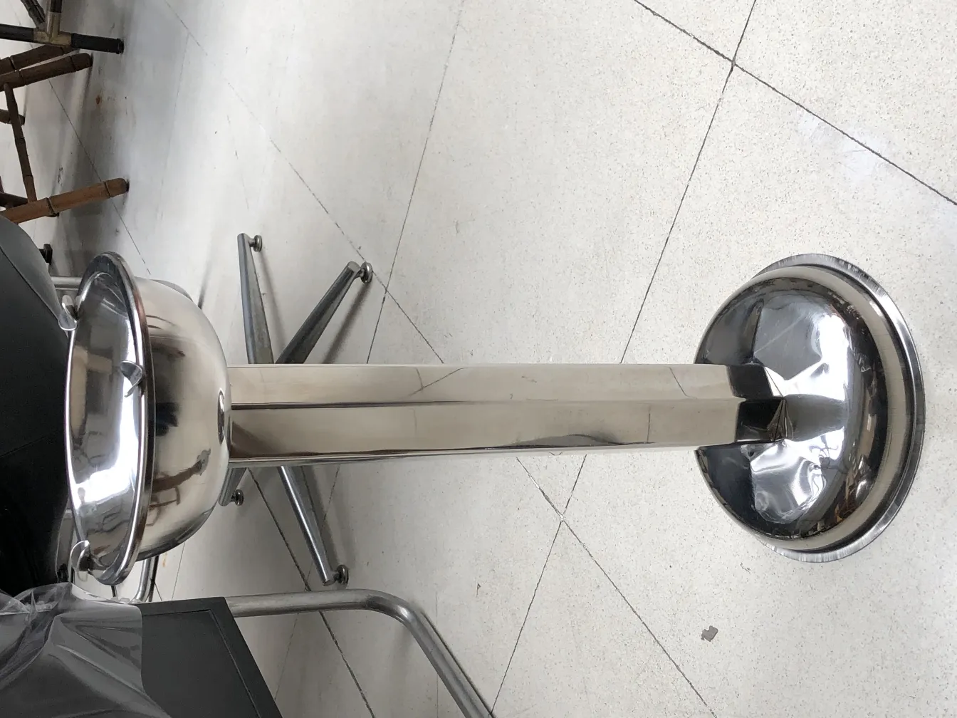 Antique standing ashtray with sleek design, placed in a modern setting.