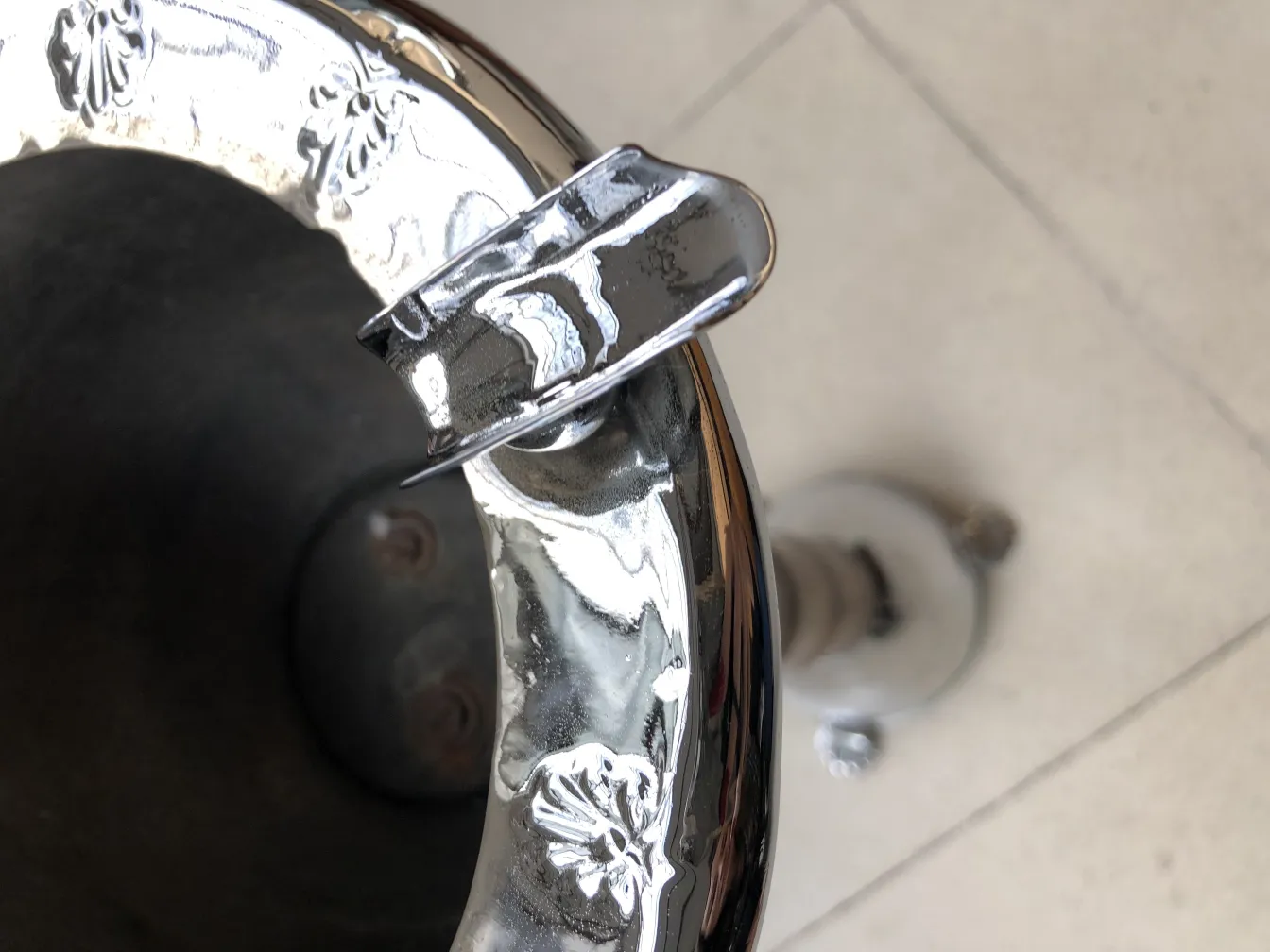 Cinzeiro de pé antigo brilhante com design decorativo, ambiente elegante.