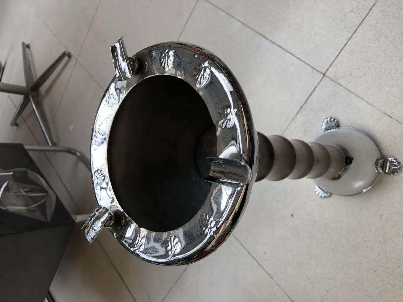 Cendrier sur pied antique orné de motifs. Fond minimaliste.