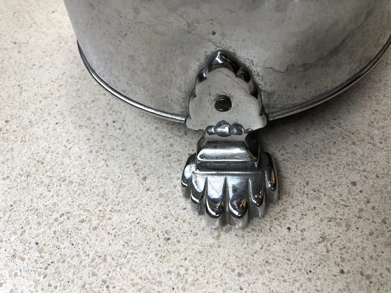 Cinzeiro de pé antigo com uma base elaborada e decorativa em fundo neutro