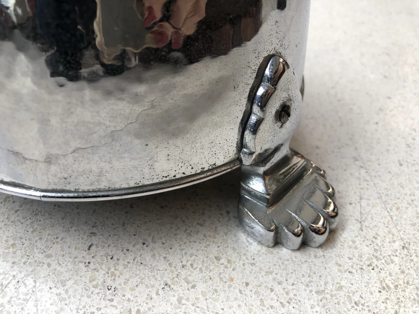 Cinzeiro de pé antigo com base em formato de pé, ambiente elegante.