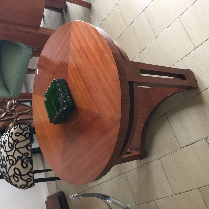 Antique standing ashtray with elegant design on a table.