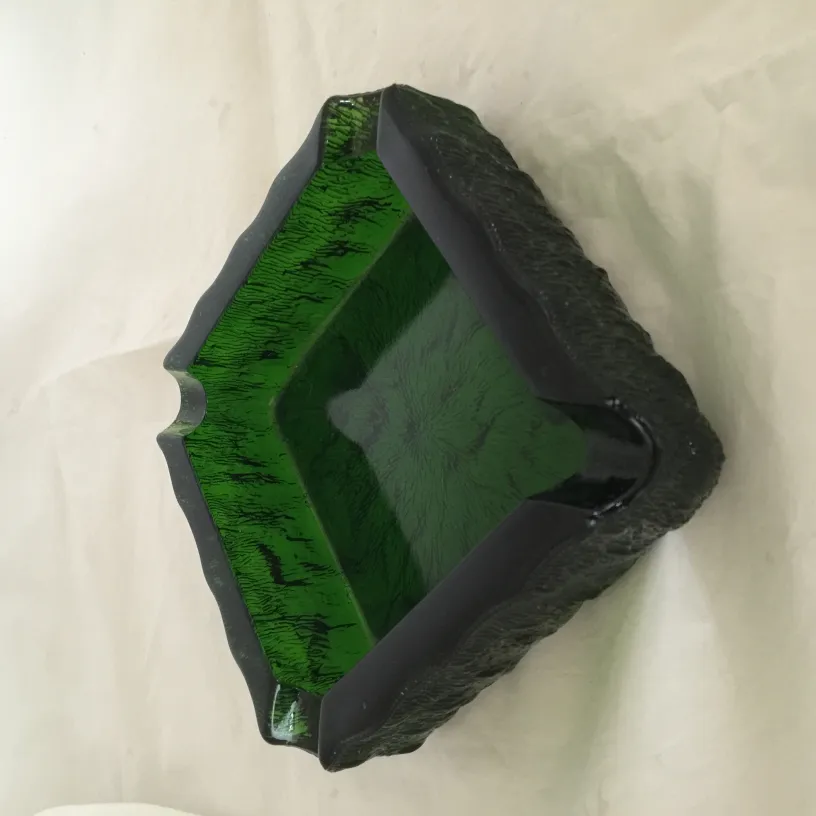 장식적인 가장자리를 가진, 생동감 있는 질감의 녹색 마감의 고전 서있는 재떨이, 사각형 모양.