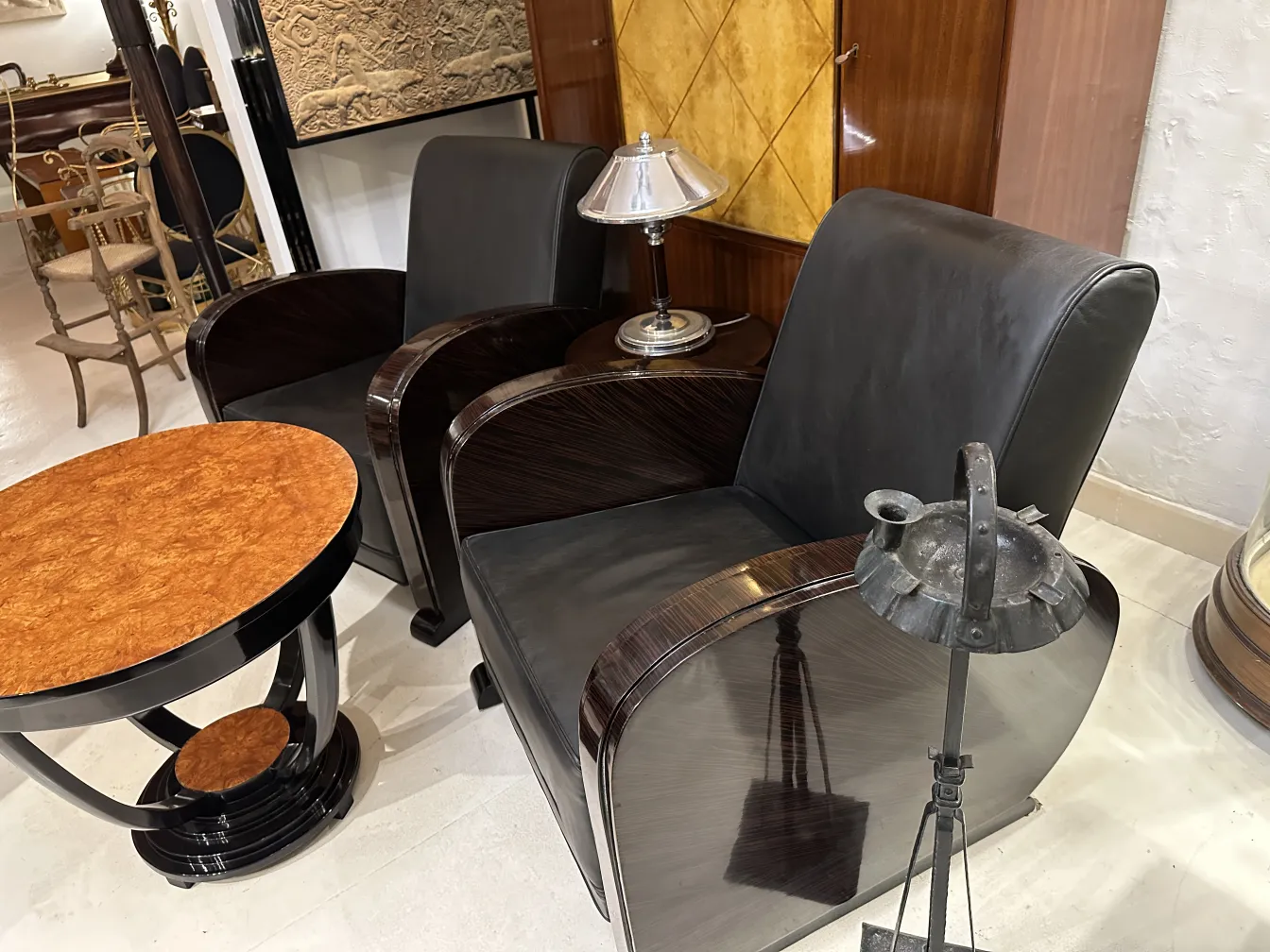 Antique standing ashtray in a room with elegant furniture, lamp and table