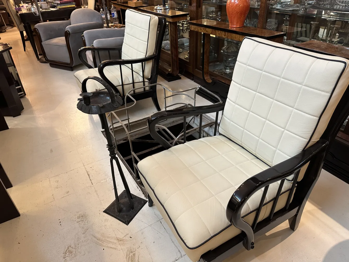 Posacenere in piedi antico con design elegante, circondato da poltrone comode.