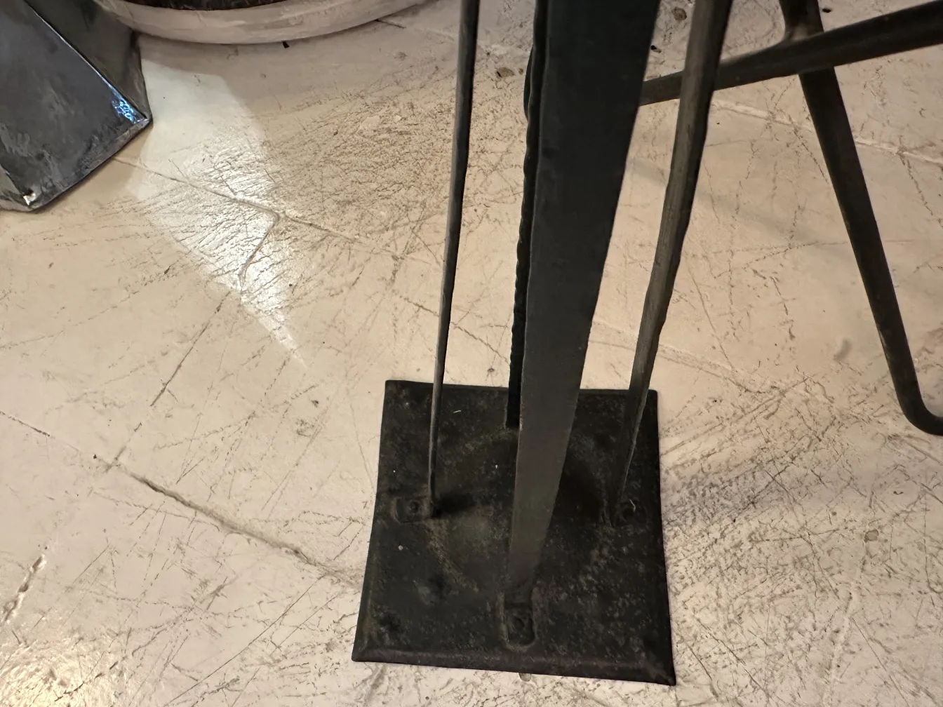 Cenicero de pie antiguo en ambiente con detalles modernos. Base sólida y diseño funcional.