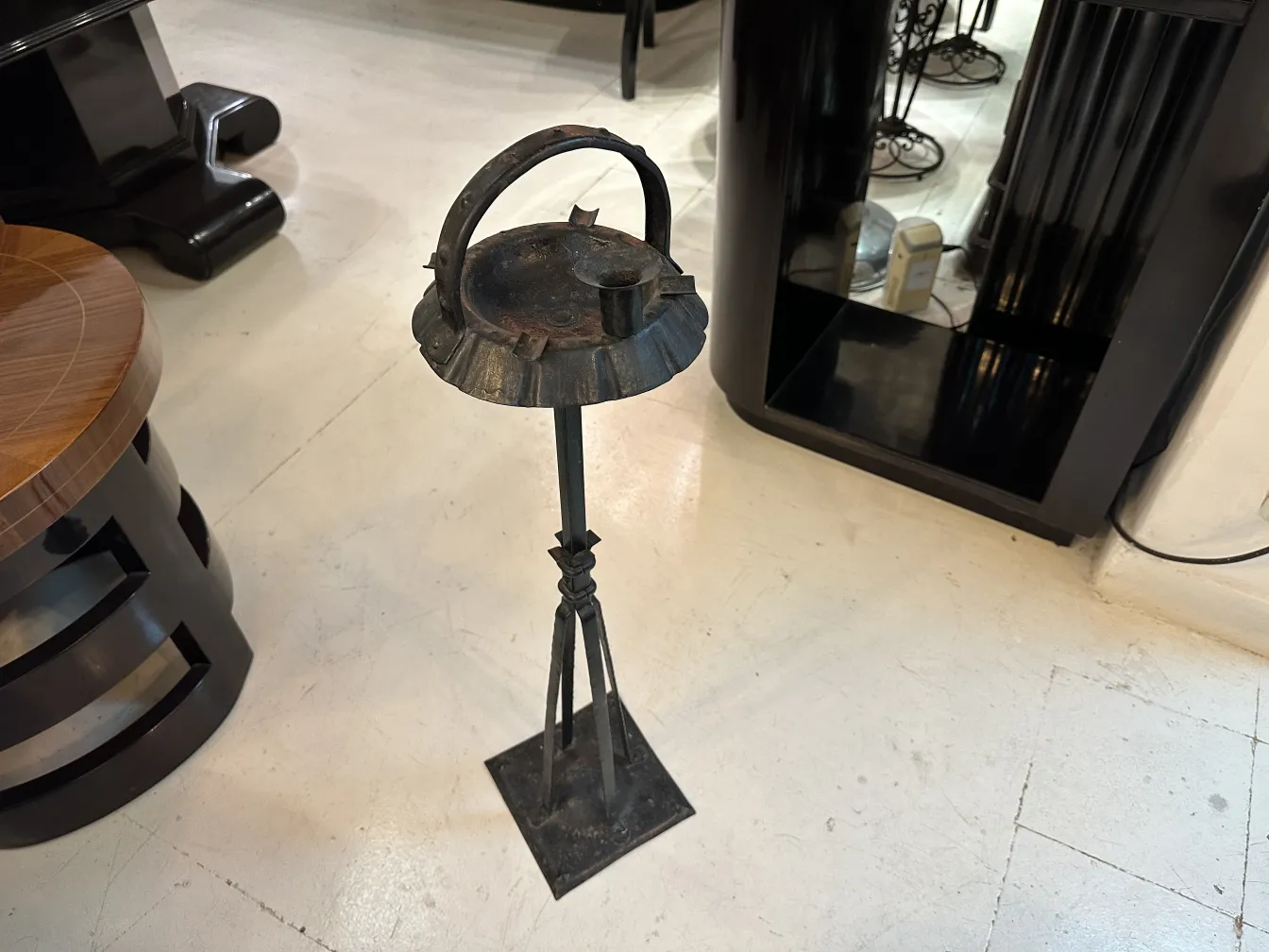 Cendrier sur pied ancien avec un design classique dans un cadre moderne.