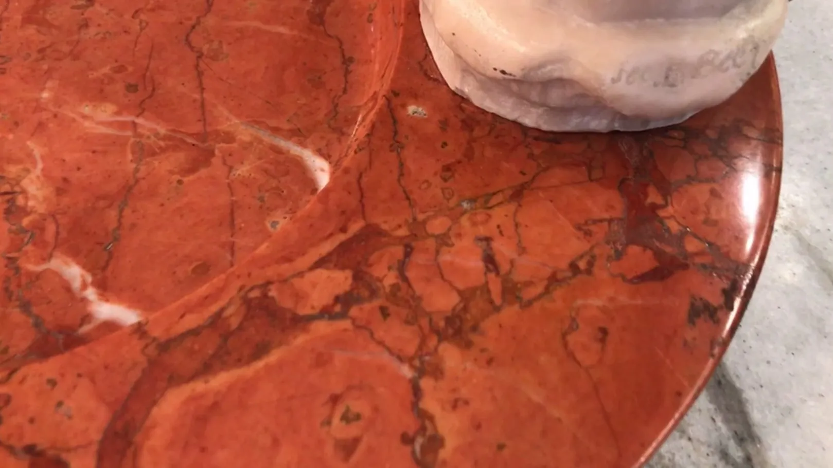 Cenicero de pie antiguo sobre superficie de mármol rojo, decorativo