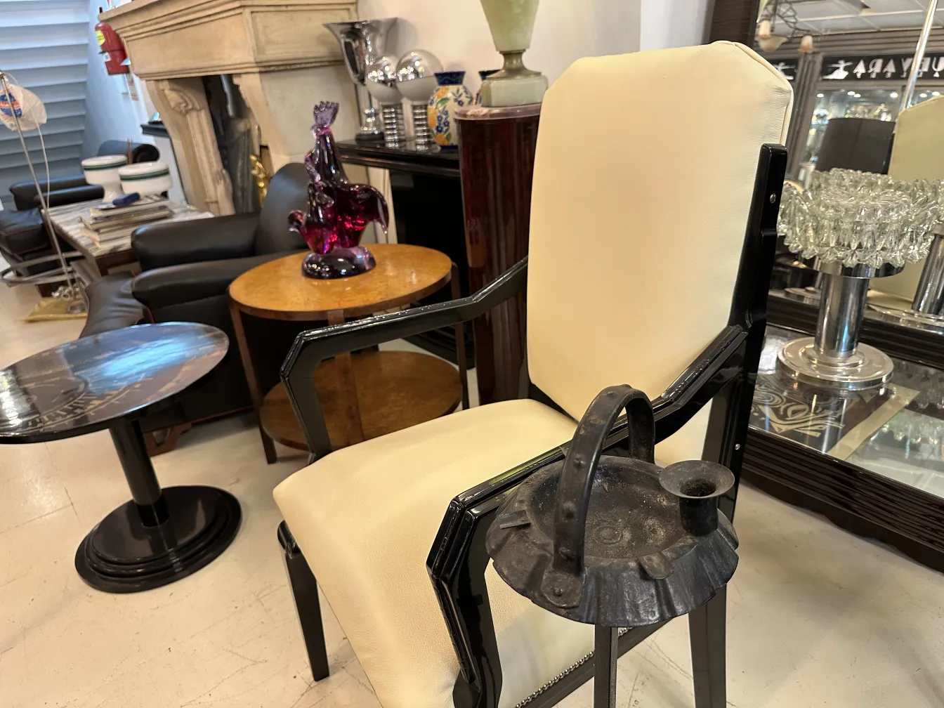 Cenicero de pie antiguo con diseño elegante en un entorno moderno con sillones.