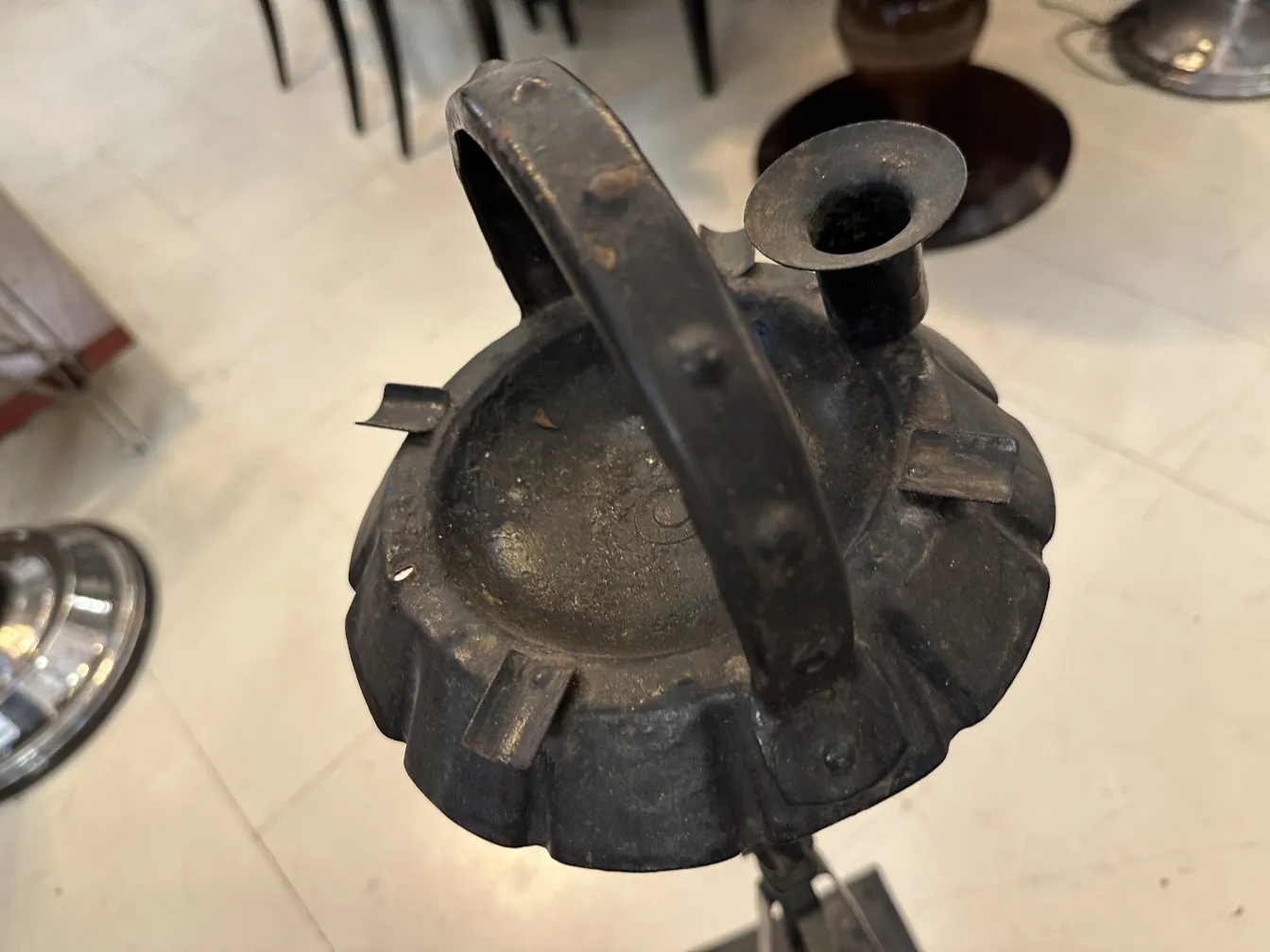 Cenicero de pie antiguo con un diseño elegante, ubicado en un entorno clásico.