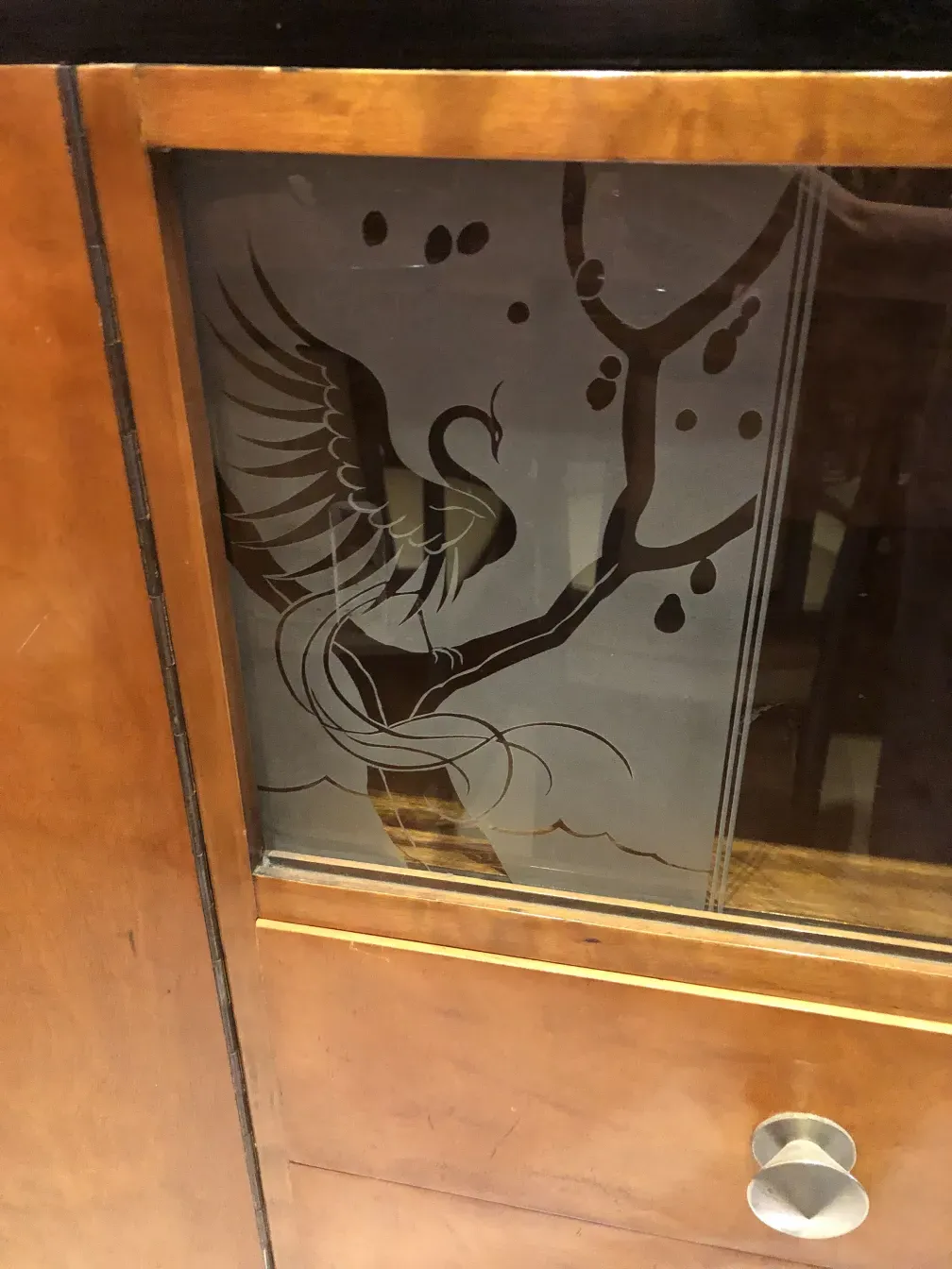 antique bookcase with glass panel decorated with a bird