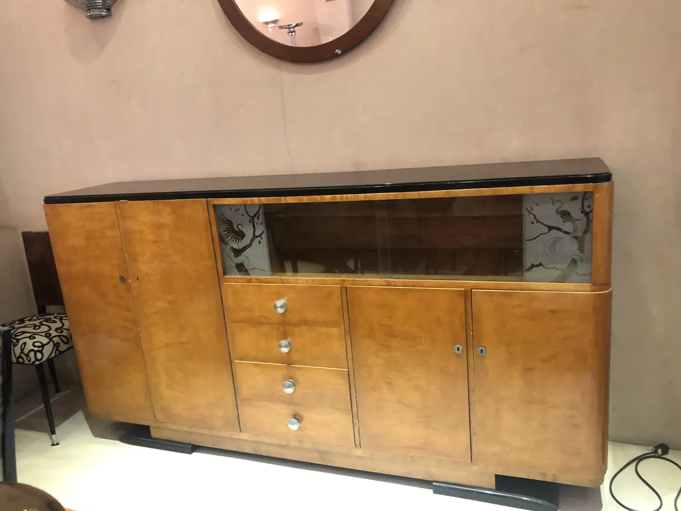 Bibliothèque antique avec étagères en verre et décorations subtiles.