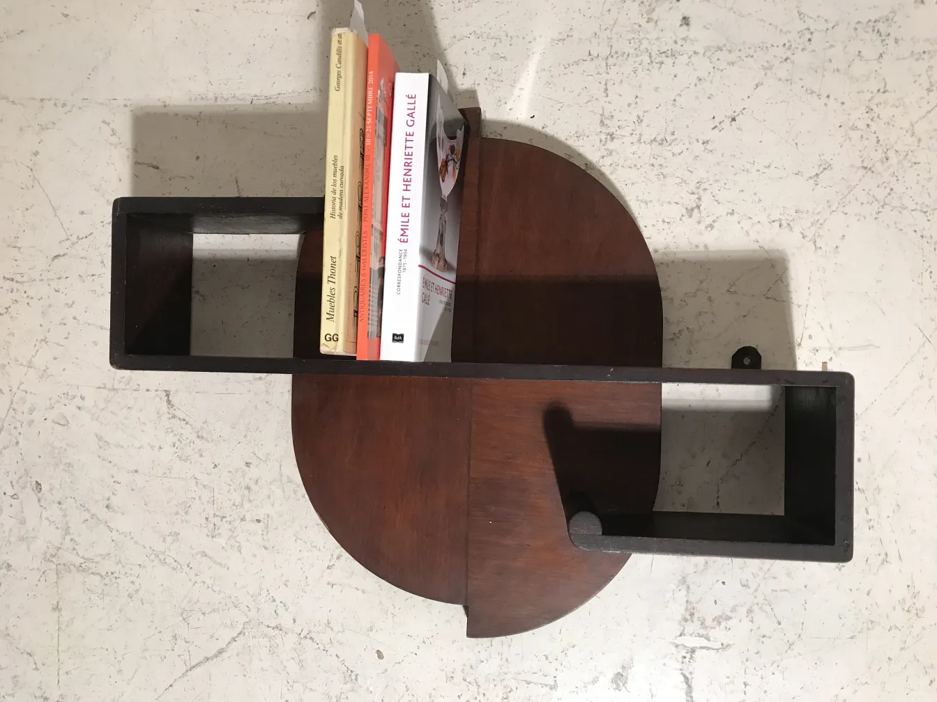 Estante de livros antigo com livros em uma superfície clara.