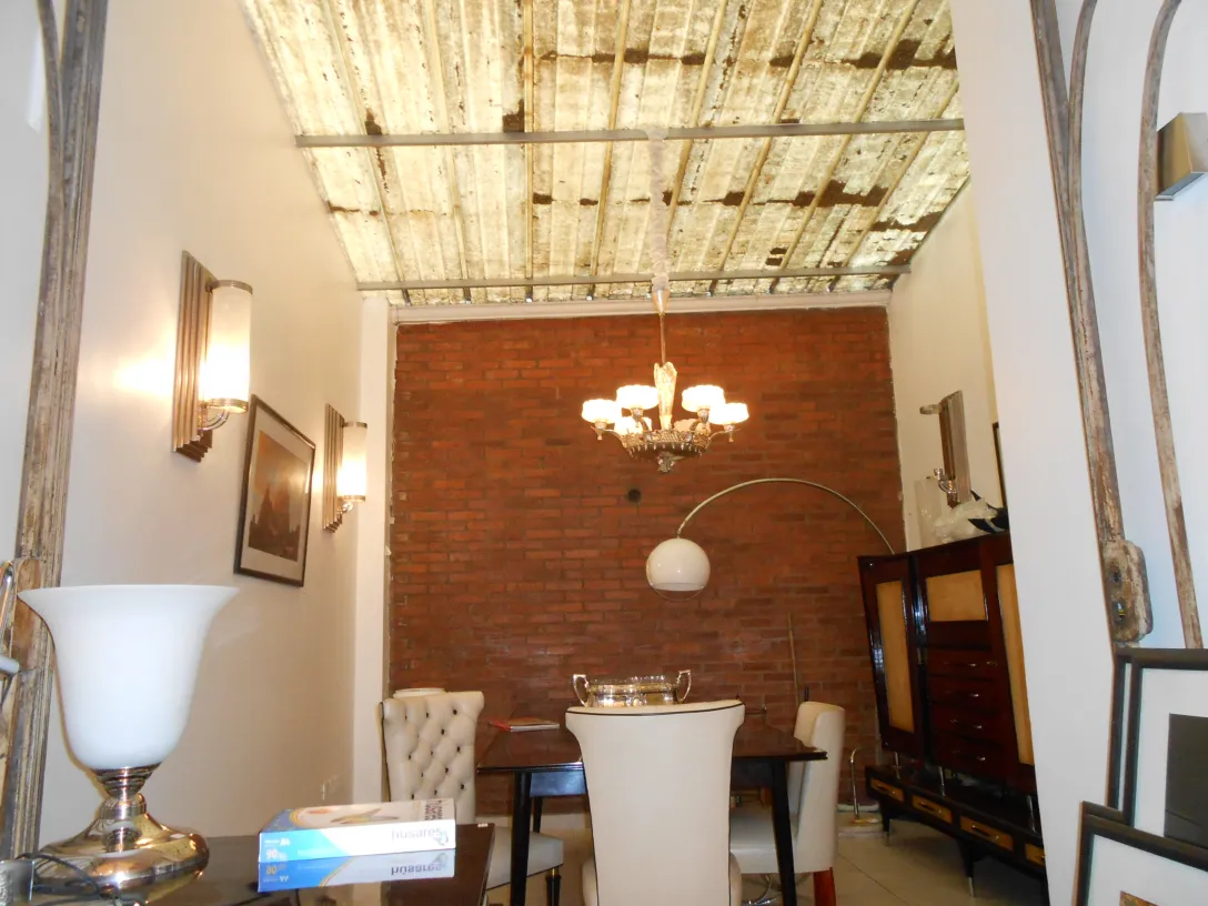 Antique bookcase in a cozy setting with soft lighting and brick walls.