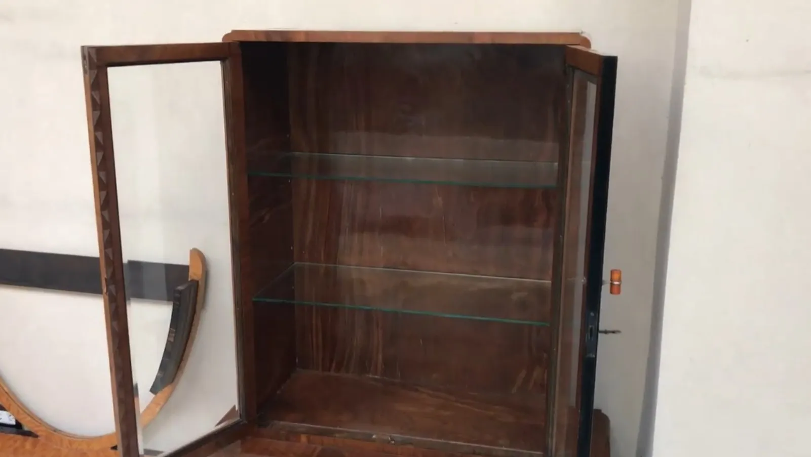 Bibliothèque ancienne avec étagères en verre, élégante et fonctionnelle.