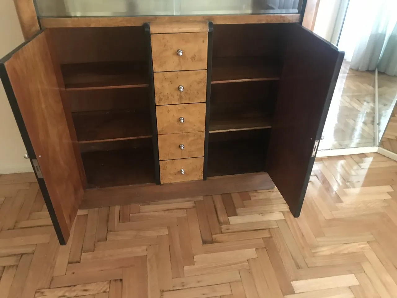 Antikes Bücherregal mit offenen Regalen und Schubladen, helles Holz.