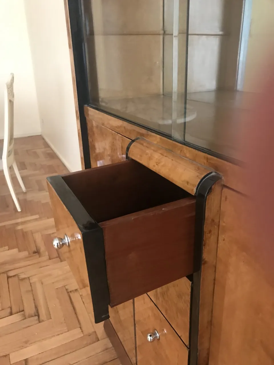 Antigua biblioteca con un diseño sencillo y un cajón visible, fondo claro.