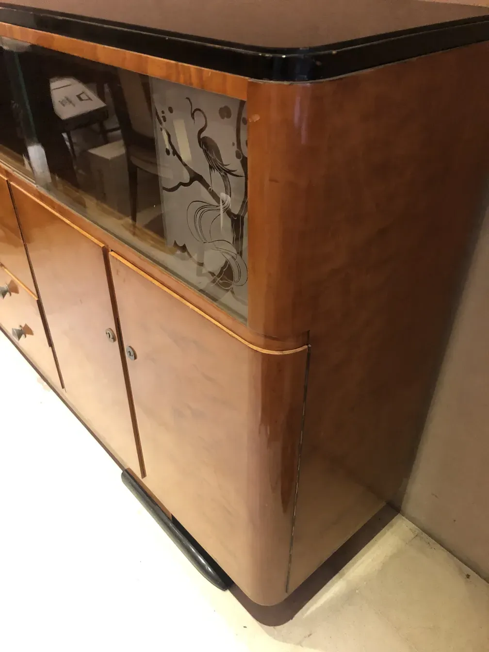 Estante de livros antigo com janelas decorativas de vidro na frente.