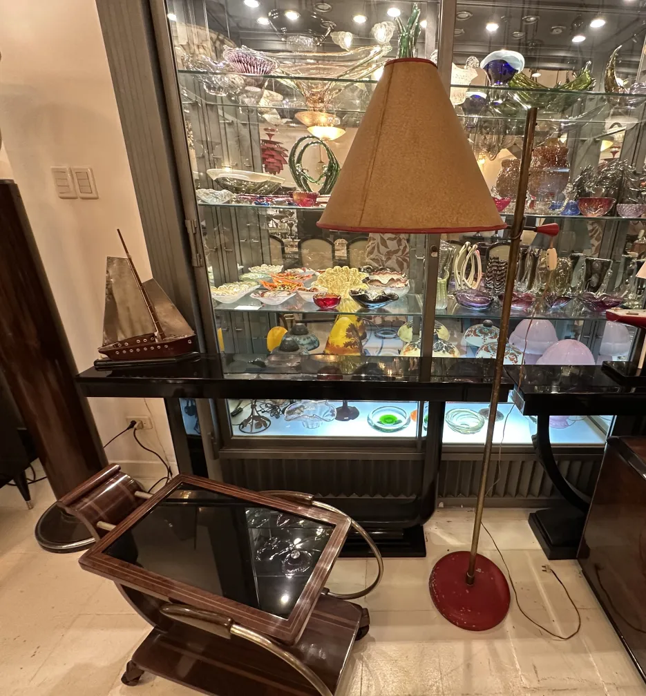 Lámpara de pie antigua de base roja y pantalla beige en un ambiente elegante