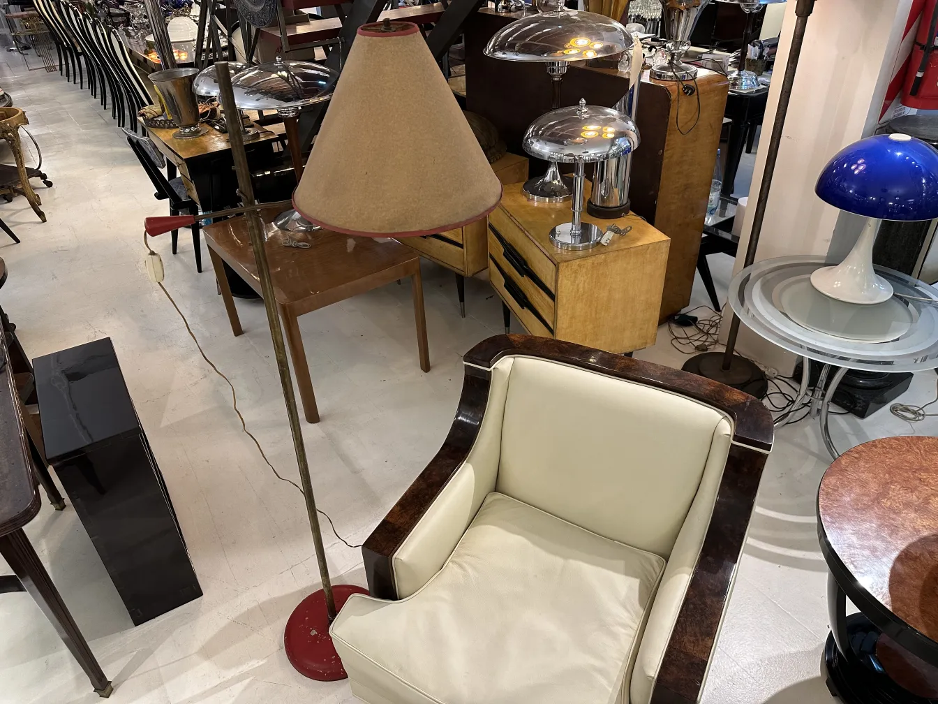 Lámpara de pie vintage con sombra en un ambiente acogedor, rodeada de otros muebles.