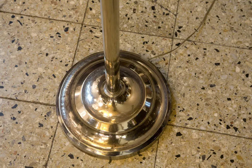 base de lámpara antigua de pie en un suelo de baldosas decorativas