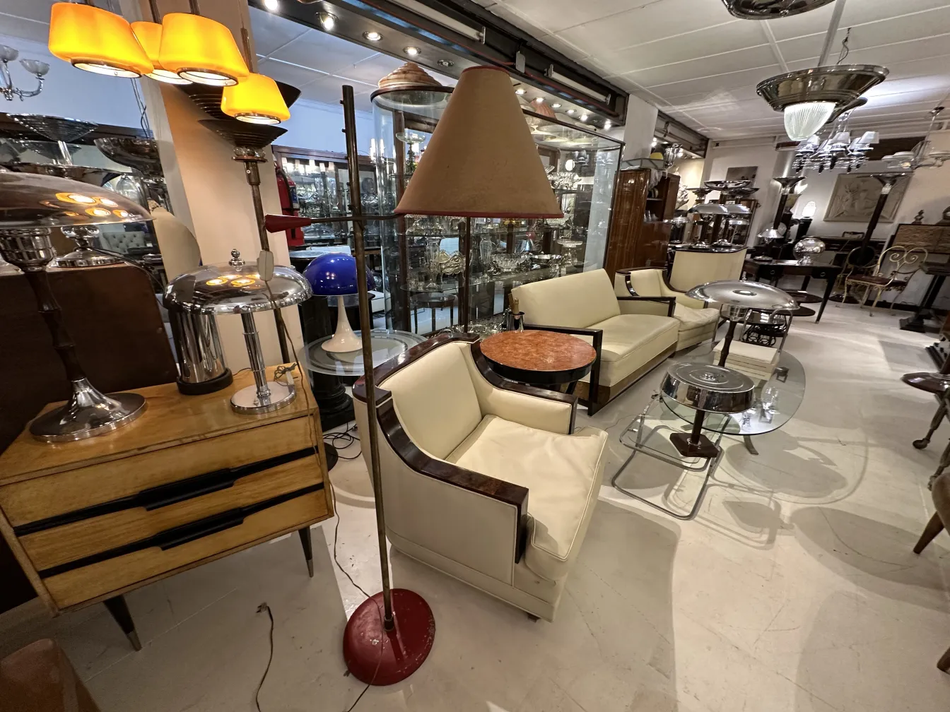 Lampada da terra antica in un elegante soggiorno con poltrone chiare e tavolino.