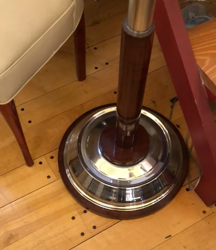 Lámpara de pie antigua con base brillante, estilo clásico en un ambiente acogedor.