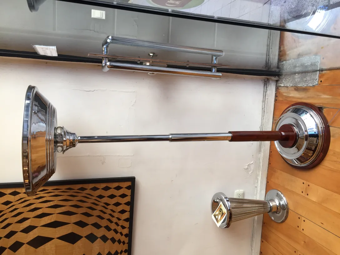 Lampada da terra antica con design elegante e base lucida, in un ambiente decorativo.