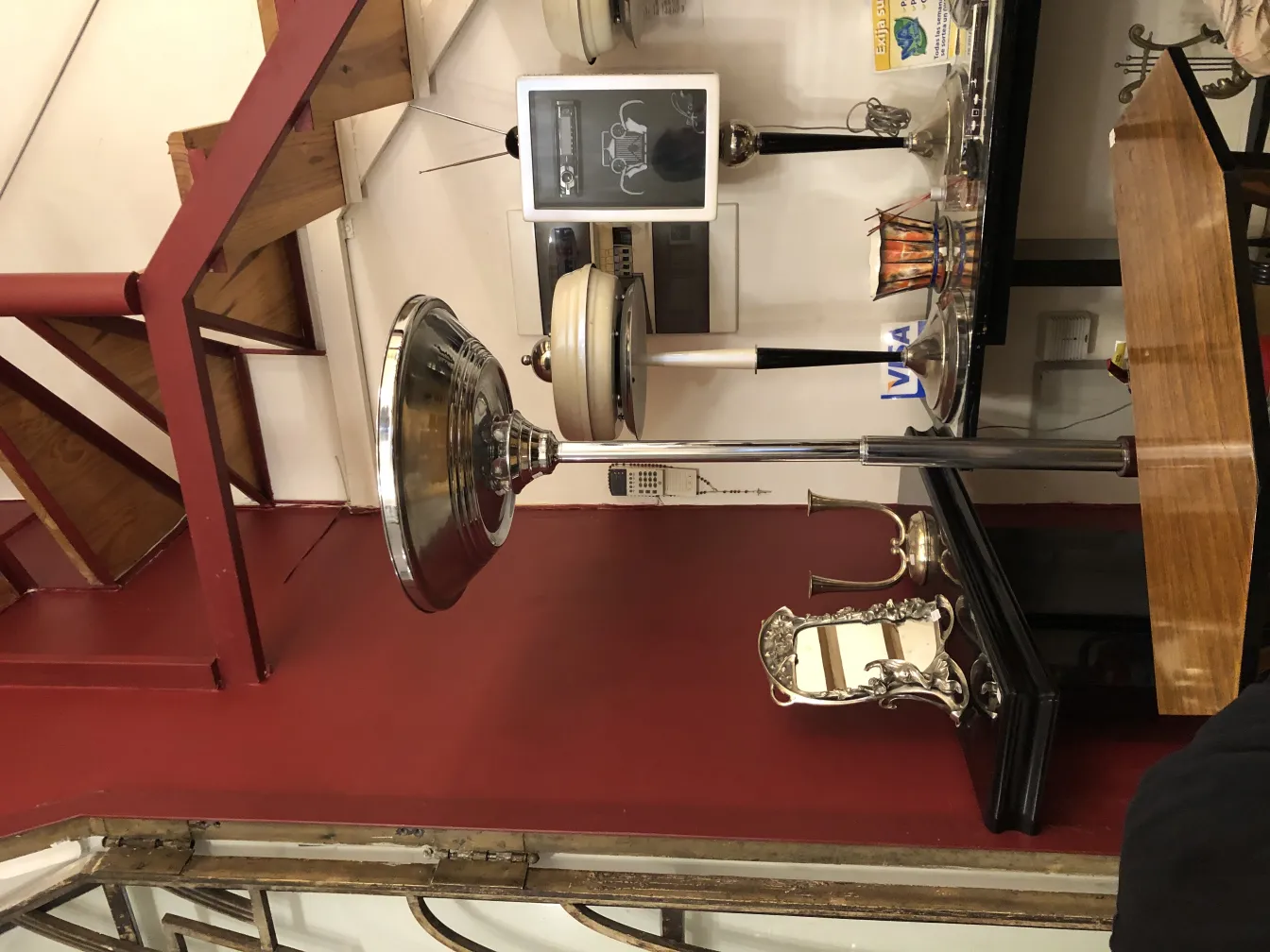 Lampada da terra antica con design elegante in un ambiente accogliente, con elementi decorativi come un tavolo e oggetti da collezione.