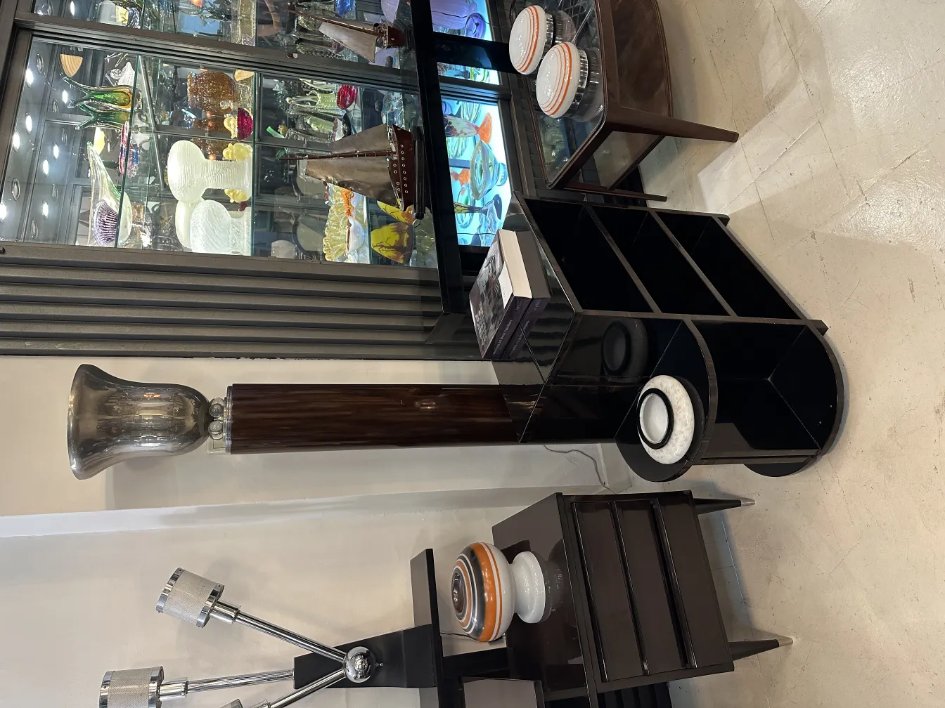 エレガントなデザインの古いフロアランプと頑丈なベース、周囲には他の装飾品があります。