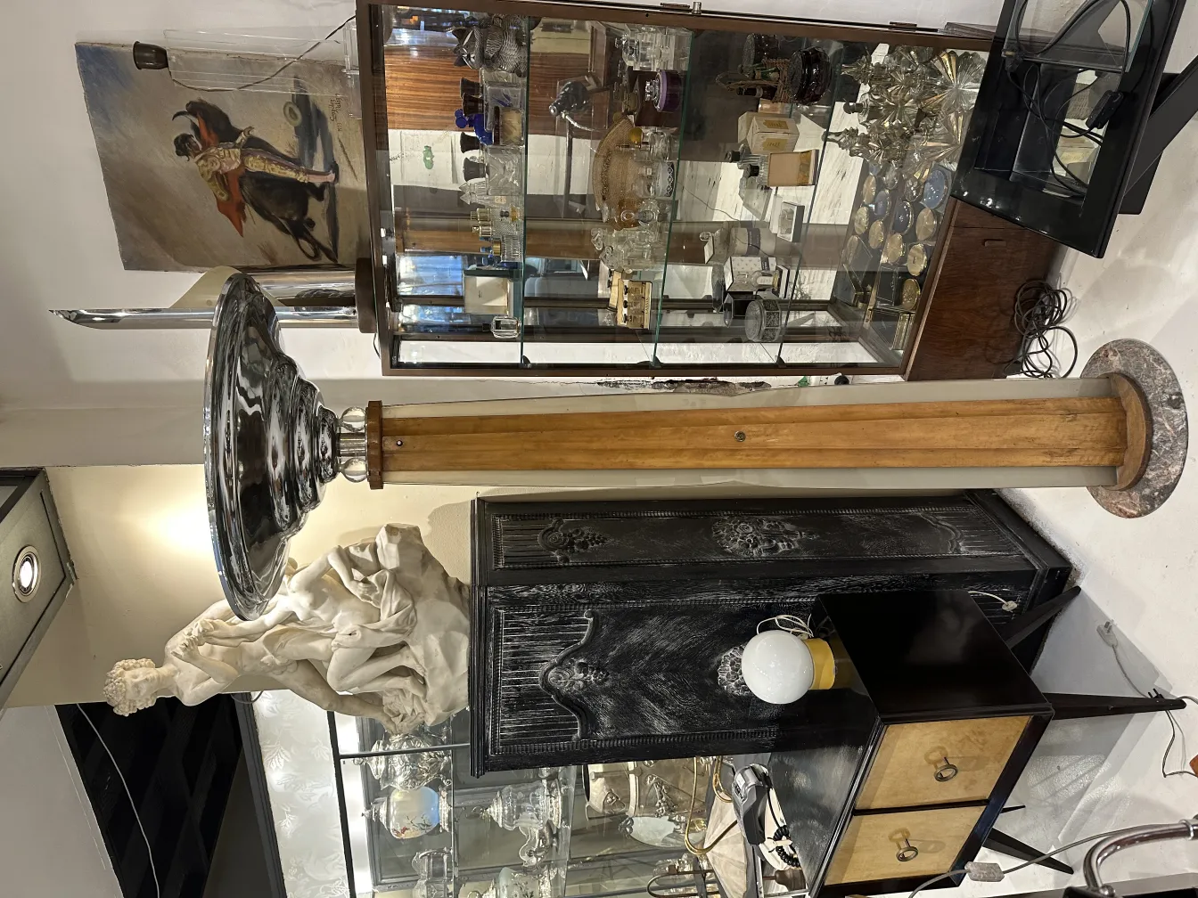 Antique floor lamp with a stylish base and wide shade in a decorated environment.