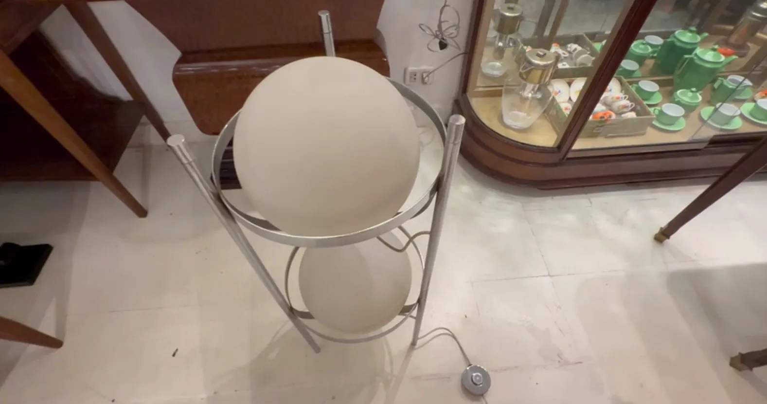 Lampada da terra antica con sfera in vetro in interno elegante.