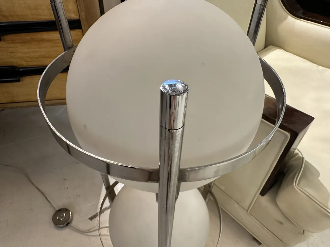 Lampada da terra antica con sfera bianca e struttura metallica, perfetta per decorare.