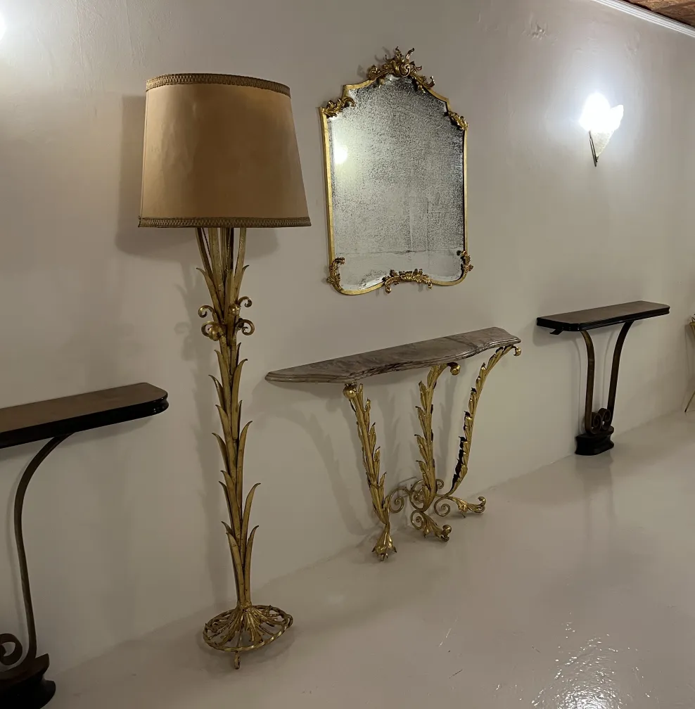 Lámpara de pie antigua con pantalla beige y base decorativa dorada.